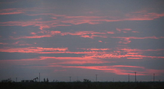 [Pink horizontal highlights are painted across a sky completely covered in purple-blue clouds.]